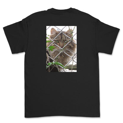 Black t-shirt with a cat behind a chain-link fence on the back